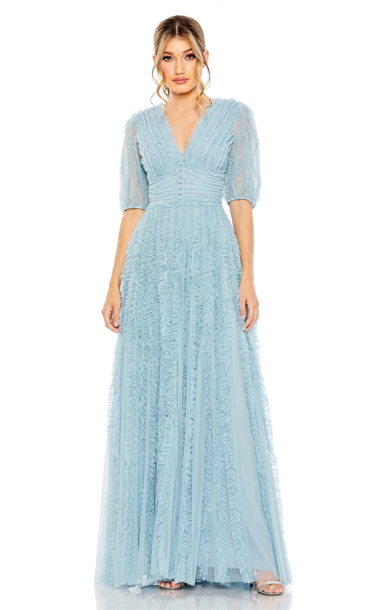 A woman wears the Long Formal Dress 8050 by Mac Duggal, featuring light blue fabric, a floor-length A-line silhouette, short puff sleeves, a V-neckline, and delicate ruffled details, standing against a plain white background.